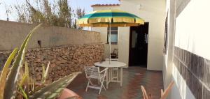 a table and chairs under an umbrella on a patio at La Casa Dei Delfini in Lampedusa