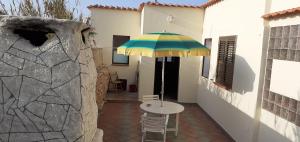 a patio with a table and an umbrella at La Casa Dei Delfini in Lampedusa