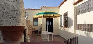 a table and chairs under an umbrella on a patio at La Casa Dei Delfini in Lampedusa