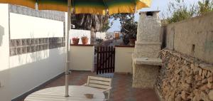 a table with an umbrella on a patio at La Casa Dei Delfini in Lampedusa
