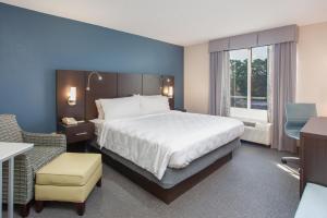 a hotel room with a large bed and a chair at Holiday Inn Hotel & Suites Tallahassee Conference Center North, an IHG Hotel in Tallahassee