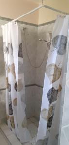 a shower curtain with leaves on it in a bathroom at La Casa Dei Delfini in Lampedusa
