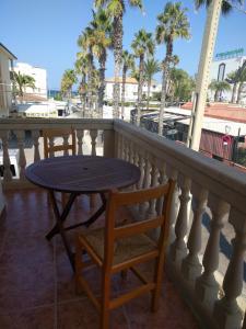 una mesa y sillas en un balcón con palmeras en CAN PICAFORT en Can Picafort