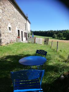 a blue table and two chairs in front of a building at gite les chaumeix in Prondines