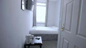 クロイドンにあるClock House Hotel - London Croydonのベッドと窓が備わる小さな客室です。