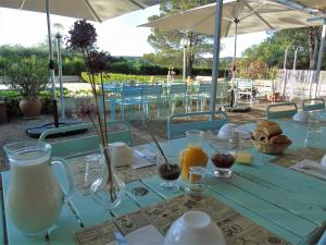 a blue table with glasses of milk and orange juice at Domaine Le Moulin Neuf in Saint-Quentin-la-Poterie