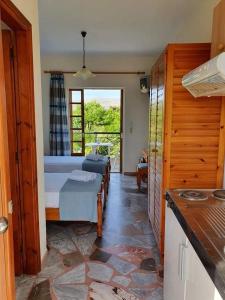 a bedroom with two beds and a kitchen with a window at Skala Eresos Paradise Studios in Skala Eresou