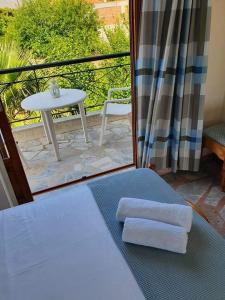 a room with a balcony with a table and towels at Skala Eresos Paradise Studios in Skala Eresou