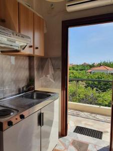 a kitchen with a sink and a window with a view at Skala Eresos Paradise Studios in Skala Eresou