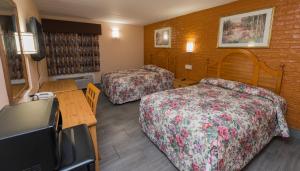 ein Hotelzimmer mit 2 Betten und einem Flachbild-TV in der Unterkunft Cambridge Inn in Cambridge