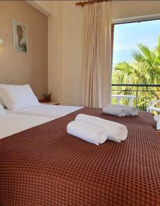 a bedroom with two beds and a large window at Skala Eresos Paradise Studios in Skala Eresou