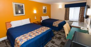 a hotel room with two beds and a television at Cambridge Inn in Cambridge