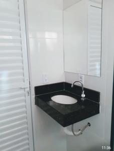 La salle de bains est pourvue d'un lavabo et d'un miroir. dans l'établissement Hotel Rosa Viva, à Barretos