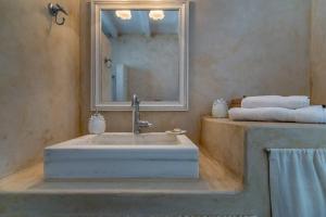 La salle de bains est pourvue d'un lavabo, d'un miroir et de serviettes. dans l'établissement Vista Mare Pollonia, à Pollonia