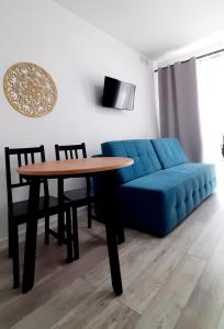 salon z niebieską kanapą i stołem w obiekcie Flamingo Apartments w mieście Międzyzdroje