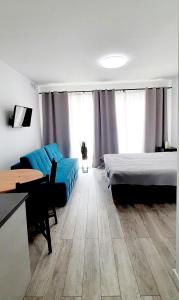 Pokój z 2 łóżkami, kanapą i stołem w obiekcie Flamingo Apartments w mieście Międzyzdroje