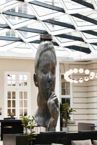 a statue of a man sitting on top of a table at Villa Copenhagen in Copenhagen