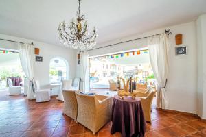 a dining room with a table and chairs and a chandelier at Hotel il Faro di Molara in Porto San Paolo