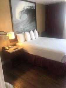 a hotel room with a bed and a table with a lamp at Kings Inn Anaheim at The Park & Convention Center in Anaheim