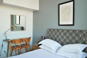 a bedroom with a bed and a desk and a mirror at Hotel Belle-Vue Vieux-Port in Marseille