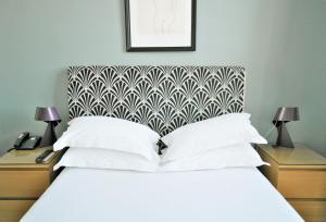 a bedroom with a white bed and two night stands with lamps at Hotel Belle-Vue Vieux-Port in Marseille