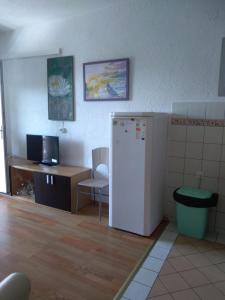 a kitchen with a refrigerator and a table and a desk at Apartment Bušljeta in Starigrad