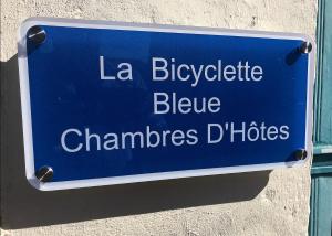 a blue sign on the side of a building at La Bicyclette Bleue in Montmorillon