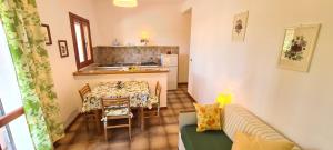 Una sala de estar con una mesa y una cocina. en Villa Vanna Bilo A - bilocale, en Capoliveri