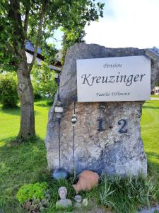 um sinal para kreiseninger em cima de uma rocha em Pension Kreuzinger, 5310 Tiefgraben em Mondsee