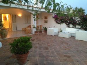a patio with white furniture and plants in a house at Villa Masai in Ostuni