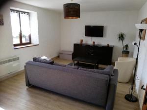 a living room with a couch and a television at gite les chaumeix in Prondines