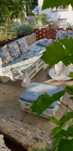 a bench with pillows on it sitting on the ground at Apartments and Rooms Ivana in Krk