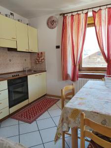 cocina con mesa, fregadero y ventana en Sky Moda Appartamento, en Livigno