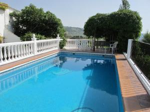 a large swimming pool with a white fence at Casa rural VillaGloria in Montefrío