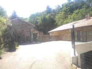a driveway in front of a stone building at Gîte au coeur du parc naturel régional du Pilat in Pélussin