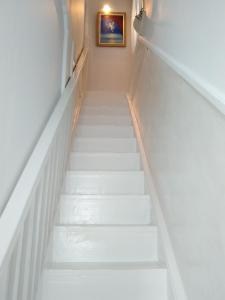 a stairway with white steps and a picture on the wall at Hermoupolis Syros Maisonette in Ermoupoli