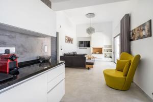 a kitchen and living room with a yellow chair at Villa Daniela in Koutsounari