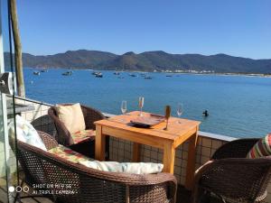 una mesa en un balcón con vistas al agua en Costão VIP! linda casa 3 quartos perto da água em Florianópolis, en Florianópolis