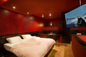 a bedroom with a bed and a flat screen tv at Tout Motel (Adults Only) in Campinas