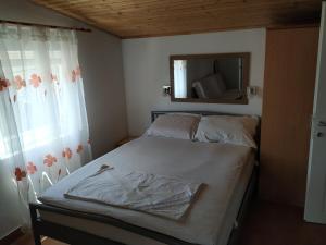 a small bedroom with a bed and a mirror at Apartment Anka in Savar