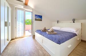 a bedroom with a large bed with towels on it at Oak Meadow Apartment in Dobrinj