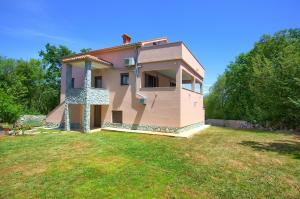 a small house in a field with a yard at Oak Meadow Apartment in Dobrinj