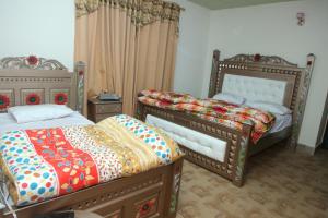 1 Schlafzimmer mit 2 Einzelbetten in der Unterkunft Hassan Hotel Thandani in Dhudiāl