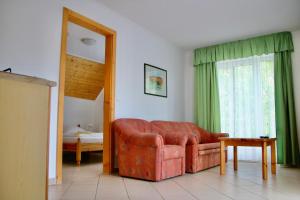 a living room with a leather couch and a mirror at Wagner Panzió in Cserszegtomaj