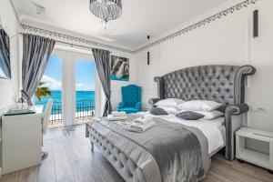 a bedroom with a large bed with a view of the ocean at Galeria Valeria Seaside Downtown - MAG Quaint & Elegant Boutique Hotels in Split