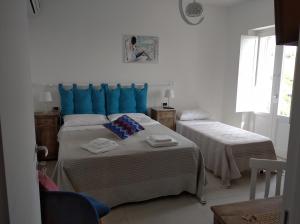 1 dormitorio con 2 camas y almohadas azules en La Casa dei Panorami di Colobraro, en Colobraro