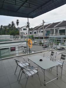 a table and chairs on a patio with a boat at WeJDAN INN BALIK PULAU, PENANG ISLAND in Balik Pulau