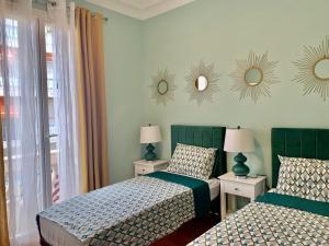 a bedroom with two beds and mirrors on the wall at D’AZUR-35 in Nice