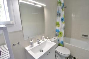 une salle de bain avec un lavabo, des toilettes et un miroir dans l'établissement ATALAYAS 153, à Peñíscola 18 autres photos