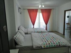 a bedroom with two beds and a window at Didy Residence in Eforie Nord